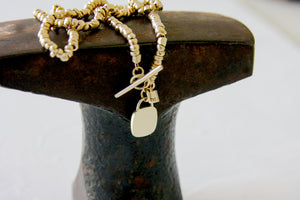 Gold beads necklace with a gold & concrete charm